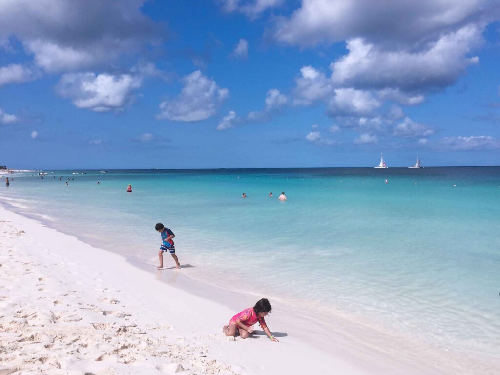 Children playing on one of the most beautiful beaches in the world with white sand and turquoise sea.