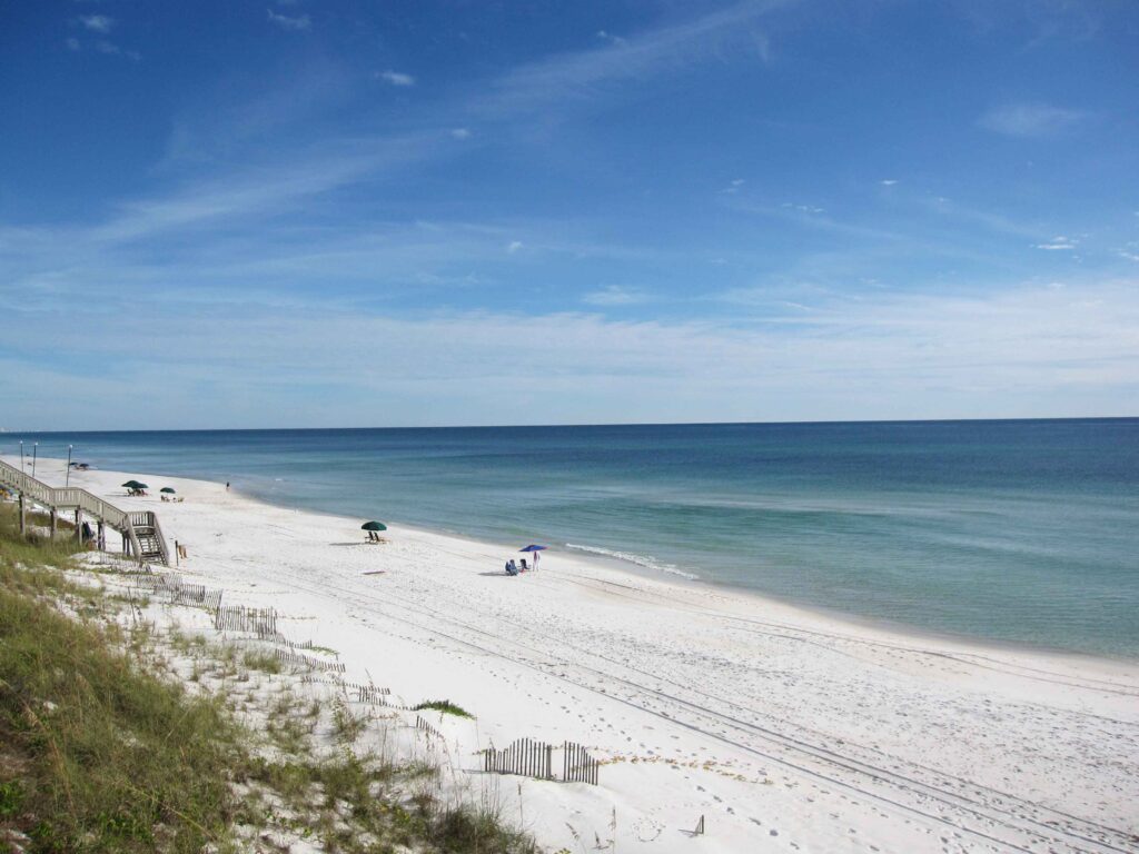 White sand beach with blue ocean stretching as far as the eye can see.